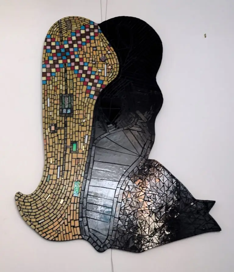 A curving, abstract mosaic artwork with a shape in gold and multicolored glass interlocked with a shape in black glass.